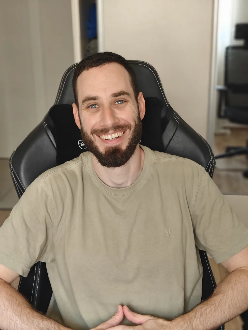 אופיר, המעצב מאחורי UXUIKIT, מחייך בכיסא המשרדי שלו